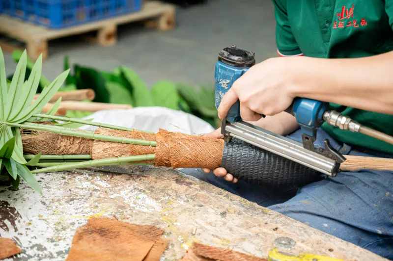 R&D technician and mold engineer in Grand Green workshop examining custom artificial tree branch mold and KD trunk connection parts